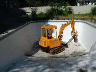 our Dublin, CA Pool Deomlition team with a bobcat in a pool